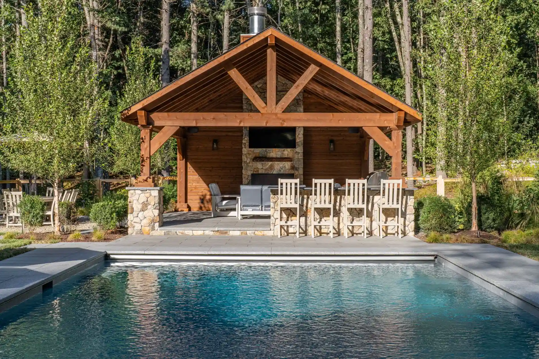 Modern pavilion structure with evening lighting and furnished outdoor living area